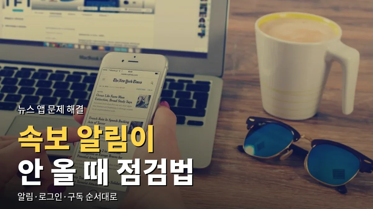 노트북 앞에서 스마트폰으로 뉴스 기사를 읽는 모습